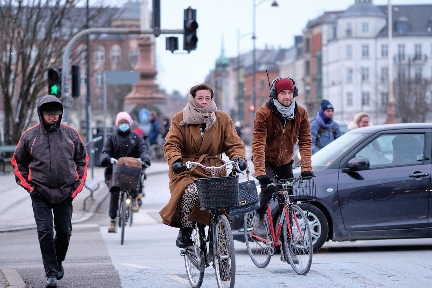 Cyclists crossing a bridge in Copenhagen in light snow